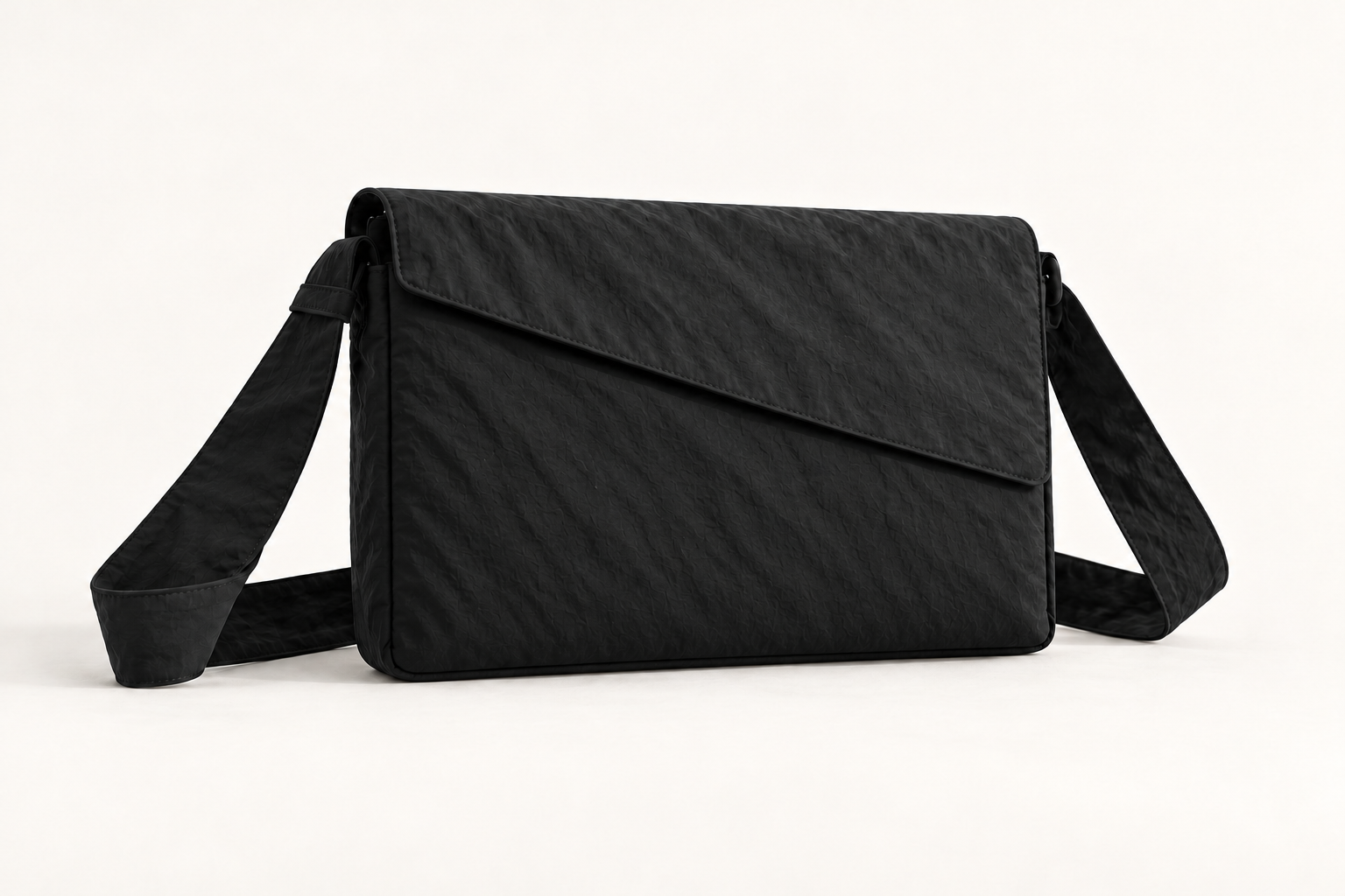 Monofloat laptop carry concept in black, with a broad accessory pocket beneath the diagonal flap.